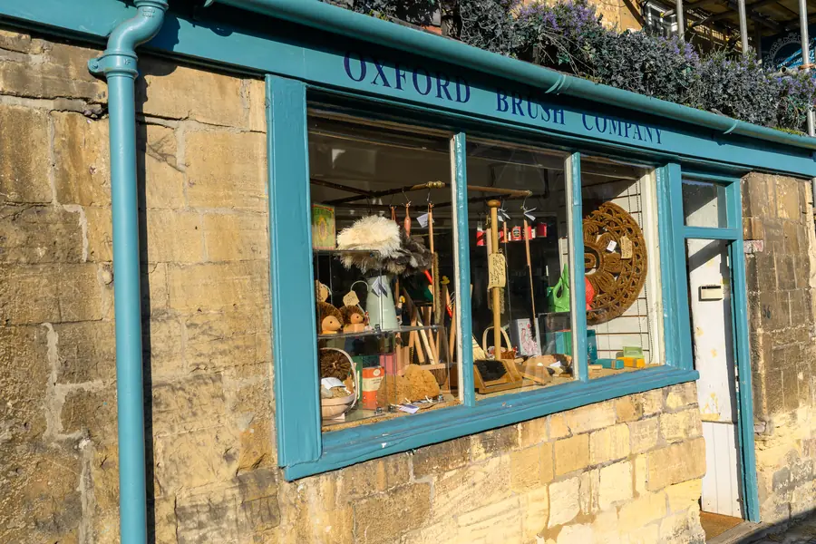 The Oxford Brush Company shopfront with teal paintwork and a window display